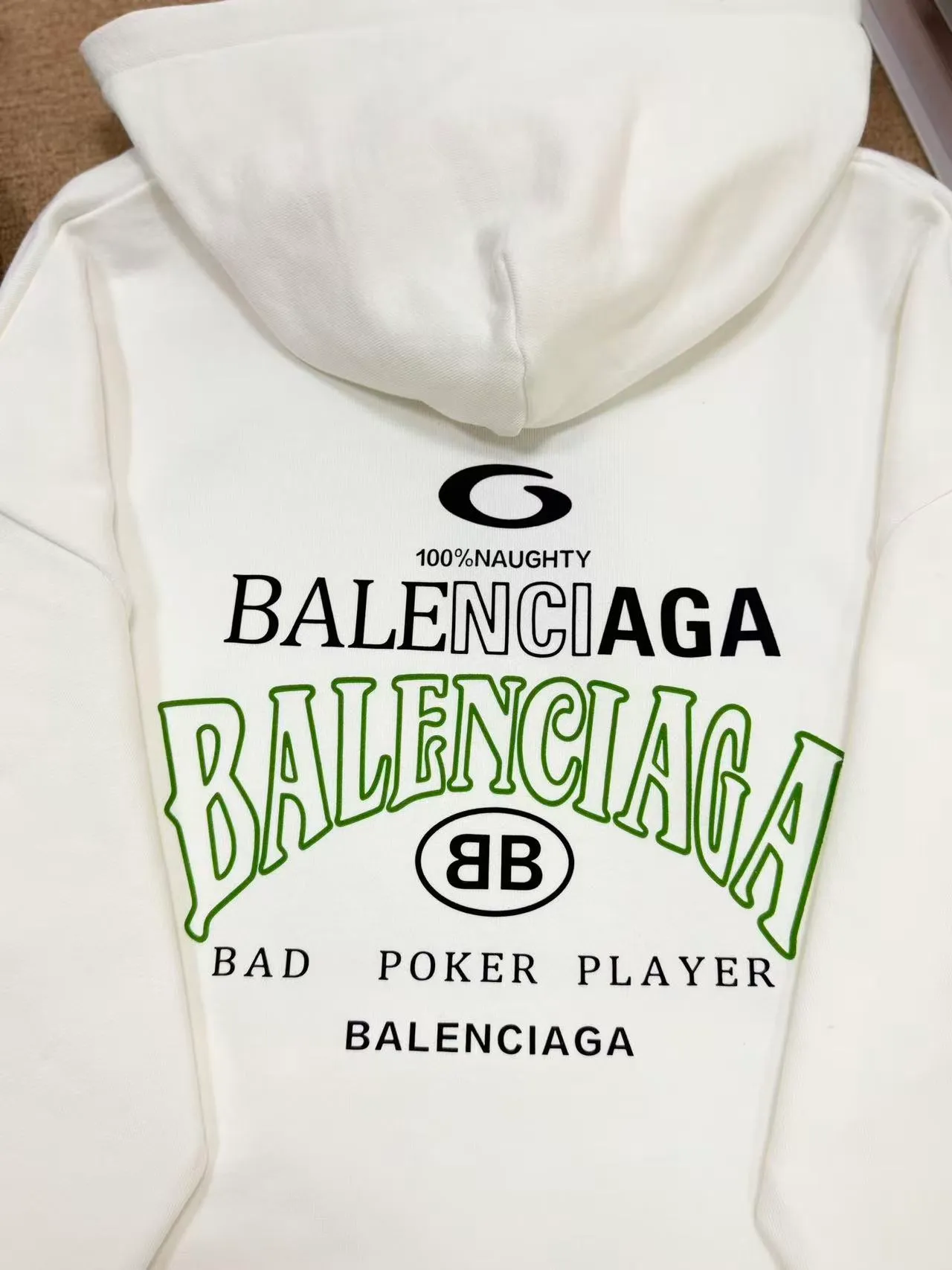 No. 2208 Style: Balenciaga Retro lettered hooded sweatshirt Color: Black, Cream White Version: Oversize loose shoulder, Same style for men and women, lazy and relaxed, covering the flesh and making you look slim Fabric: 430g high gram weight pure cotton terry fabric, soft and thick, with good drape, the upper body is not easy to wrinkle. Design highlights 1. White model: The small logo on the chest is simple and clean, minimalist and low-key style, and the daily Versatile is not picky. 2. Black model: Multi-layered Retro letter printing on the back, white rose red contrasting colors, strong layering, full of trendy atmosphere, the back printing is the visual focus of the entire dress. 3. Classic kangaroo pocket + adjustable drawstring brim, threaded cuffs and hem, Wear-Resistant is not easy to deform, and the workmanship is neatly routed. Wearing scenarios: Suitable for daily outings, commuting, and casual outings. Black is cool and stylish, and looks trendy when paired with jeans, wide-leg pants, and overalls; White is refreshing and simple, suitable for gentle casual style, and can also be worn as a couple's style. Washing and care tips: Machine wash/hand wash with cold water on the reverse side, do not rub the printed area vigorously, and dry in a cool place to avoid exposure to the sun, which may cause the print to crack and fade.